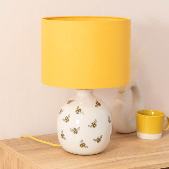 Picture of Bumble Bee Table Lamp with White Ceramic Base And Yellow Lampshade Creating  Warm Living Room Glow