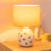 Picture of Bumble Bee Table Lamp with White Ceramic Base And Yellow Lampshade Creating  Warm Living Room Glow