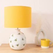 Picture of Bumble Bee Table Lamp with White Ceramic Base And Yellow Lampshade Creating  Warm Living Room Glow